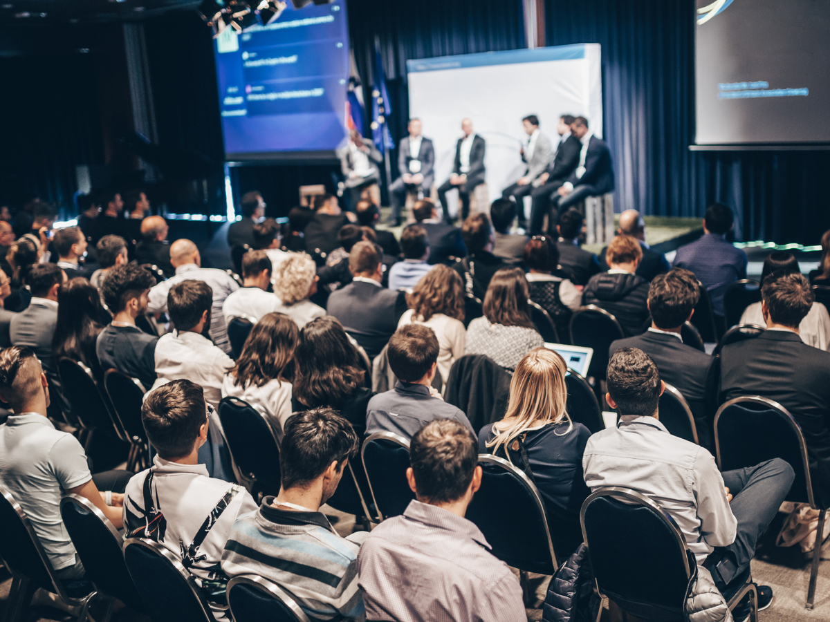 Conferentiezaal met mensen die luisteren naar een presentatie op een zakelijk evenement. Ondersteund door AV-apparatuur zakelijke evenementen
