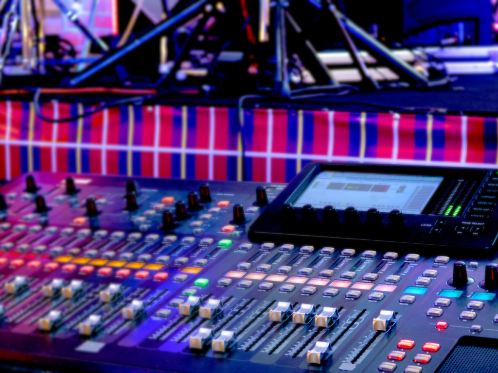 Een professioneel mengpaneel met verlichte knoppen en digitale interface, gebruikt voor het afstemmen van geluid en LED-schermen bij evenementen. De combinatie van hoogwaardige geluidstechnologie en visuele LED-opstellingen zorgt voor een indrukwekkende beleving en vlekkeloze productie tijdens live evenementen.