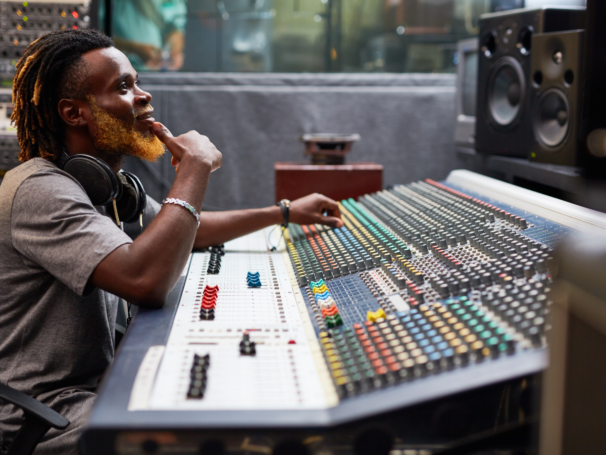 Geluidstechnicus werkt met grote audiomixer in een professionele studio