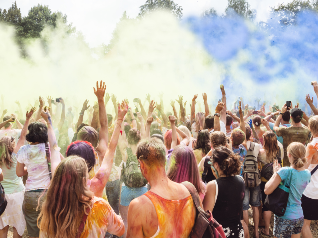 Festivalpubliek viert kleurrijk evenement met kleurpoeder in de lucht