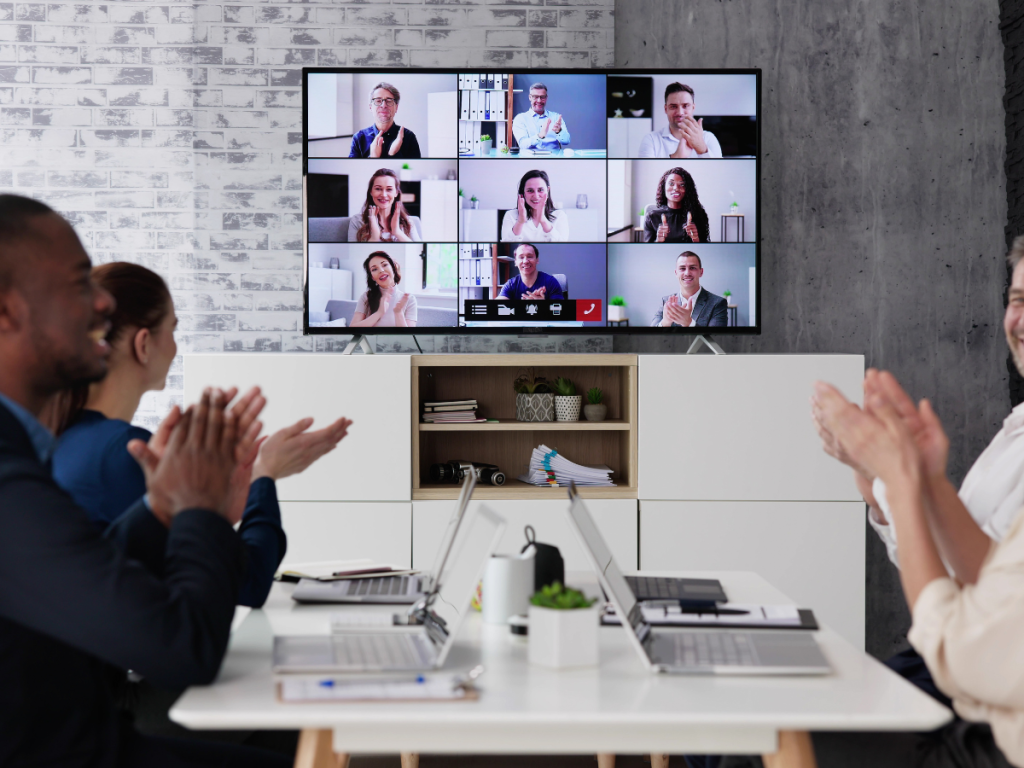 Hybride vergadering met deelnemers op locatie en via videoscherm in zakelijke setting